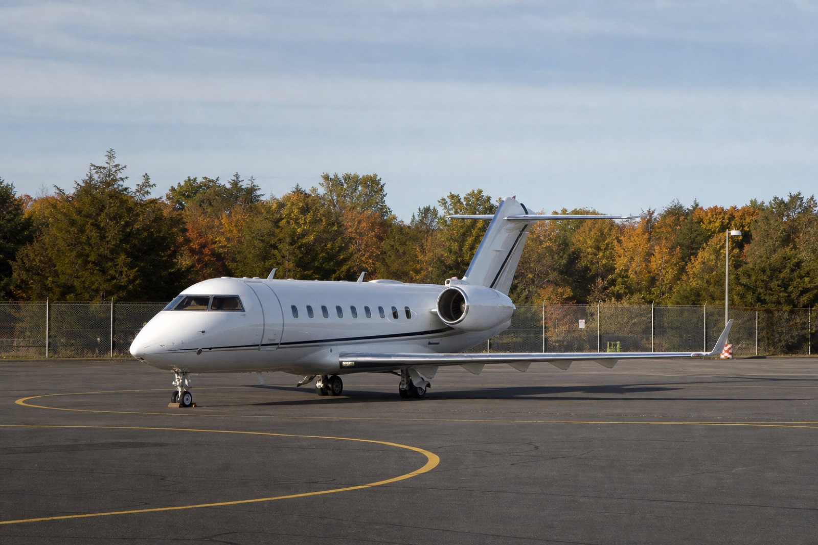 Business jet on a quiet regional airport ramp in early autumn light